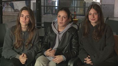 Entrevista a tres jóvenes con ropa informal: chaqueta gris, chaqueta negra de cuero y sudadera, y jersey gris oscuro.  Se infiere que hablan sobre el impacto de la pandemia en sus vidas.