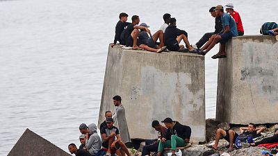 La Policía agrupa a cientos de migrantes que regresaron al Trampolín mientras se realiza la limpieza de la playa ceutí