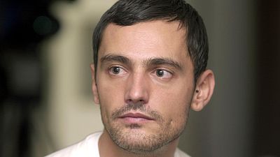 Retrato de un hombre con cabello y barba cortos, oscuro, y un pendiente; expresión seria, mirando a la izquierda; fondo oscuro y desenfocado. Retrato de un hombre con cabello y barba cortos, oscuro, y un pendiente; expresión seria, mirando a la izquierda; fondo oscuro y desenfocado.