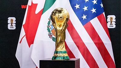 Trofeo de la Copa Mundial sobre pedestal con banderas de Canadá, México y EEUU al fondo. Imagen relacionada con el sorteo del Mundial 2026. Trofeo de la Copa Mundial sobre pedestal con banderas de Canadá, México y EEUU al fondo. Imagen relacionada con el sorteo del Mundial 2026.