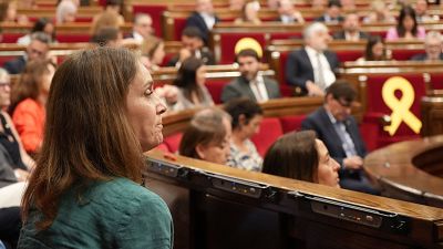 Jéssica Albiach, presidenta de los Comuns en el Parlament, de perfil derecho, con camisa verde azulado y expresión seria, en el hemiciclo tras una votación. Se aprecia un lazo amarillo en el fondo. Jéssica Albiach, presidenta de los Comuns en el Parlament, de perfil derecho, con camisa verde azulado y expresión seria, en el hemiciclo tras una votación. Se aprecia un lazo amarillo en el fondo.