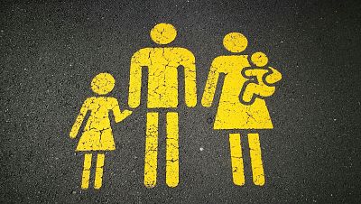 Pintura amarilla desgastada en asfalto, representando una familia (padre, madre con bebé y niña) con trazos simples. Pintura amarilla desgastada en asfalto, representando una familia (padre, madre con bebé y niña) con trazos simples.