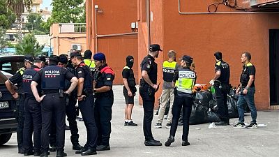 Confiscación de mercancía en operación anti-top manta. Varios agentes de diferentes cuerpos policiales, algunos con chalecos reflectantes, junto a bolsas de basura. Confiscación de mercancía en operación anti-top manta. Varios agentes de diferentes cuerpos policiales, algunos con chalecos reflectantes, junto a bolsas de basura.