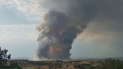 Gran columna de humo gris y marrón, similar a un hongo, sobre campos de cultivo. Cielo con nubes y humo. Pirocúmulo. Gran columna de humo gris y marrón, similar a un hongo, sobre campos de cultivo. Cielo con nubes y humo. Pirocúmulo.