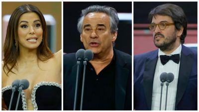 Tres personas, vestidas de gala, reciben premios; una mujer con vestido negro y dos hombres con trajes oscuros, uno de ellos con gafas.