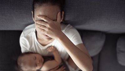 Madre superada con un bebé en brazos. Madre superada con un bebé en brazos.