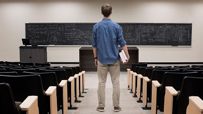 Un estudiante universitario frente a la pizarra de clase.