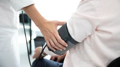 Una professional sanitària pren la tensió a una persona gran