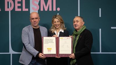 Acuerdo para la subida del SMI a 1184€ mensuales en 14 pagas, firmado por Yolanda Díaz con representantes de CCOO y UGT.  Se observa a tres personas sosteniendo el documento del acuerdo.