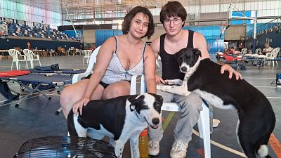 Uriel y Mariana junto a sus perras, Bimba y Lola, en el pabellón de Larrucha, tras ser desalojados por el incendio de Almería Uriel y Mariana junto a sus perras, Bimba y Lola, en el pabellón de Larrucha, tras ser desalojados por el incendio de Almería