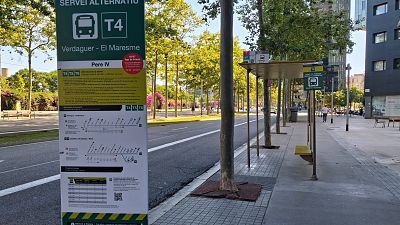 Señal de servicio alternativo T4 en Barcelona, con información sobre el Tour de France y rutas afectadas. Incluye logotipos de TMB y Ajuntament. Señal de servicio alternativo T4 en Barcelona, con información sobre el Tour de France y rutas afectadas. Incluye logotipos de TMB y Ajuntament.