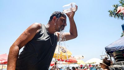 Un hombre se refresca en Rio de Janeiro, Brasil, en plena ola de calor este diciembre