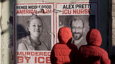 Unos niños observan carteles en homenaje a Alex Pretti y Renee Nicole Good, ambos abatidos por agentes federales de inmigración el pasado mes de enero
