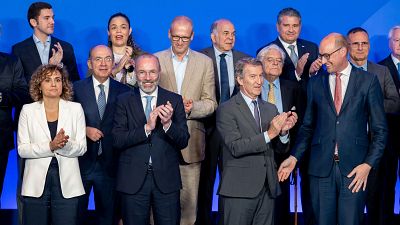 Grupo de personas, incluyendo a Cuca Gamarra, Alberto Núñez Feijóo y Manfred Weber, aplaudiendo y sonriendo en un evento con fondo azul. Grupo de personas, incluyendo a Cuca Gamarra, Alberto Núñez Feijóo y Manfred Weber, aplaudiendo y sonriendo en un evento con fondo azul.