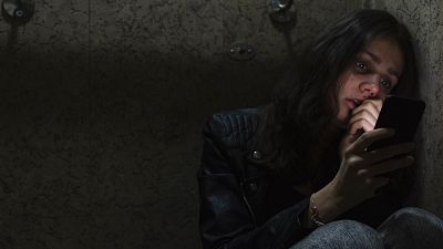 Una mujer asustada mira su teléfono Una mujer asustada mira su teléfono