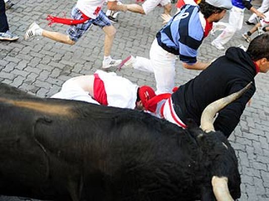 San Fermín - l toro tropieza con varios mozos en Estafeta