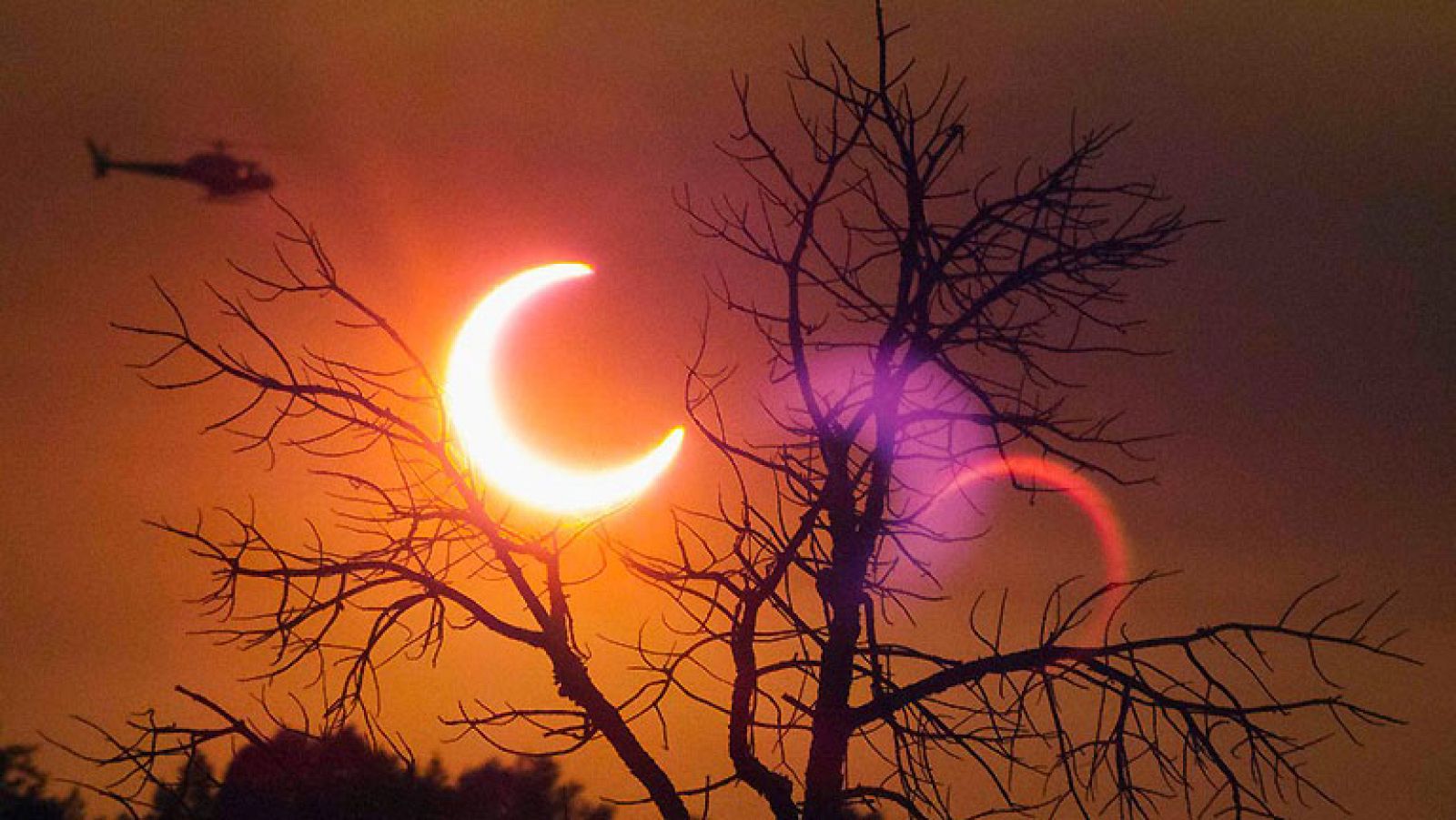Un eclipse parcial de Sol ha sido visible este lunes en zonas de Asia (al amanecer) y Estados Unidos (al atardecer), en el primer acontecimiento de estas características que se puede observar  en los últimos 18 años, según ha informado la NASA.