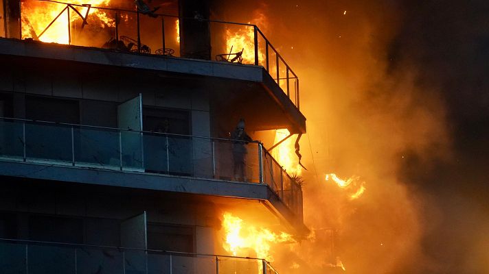 Una persona en un balcón del edificio en llamas, en el barrio de Campanar