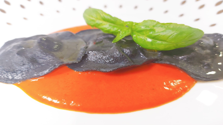 Saber vivir - Raviolis negro rellenos de calamar acompañado de pimientos