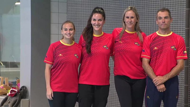 Cuatro miembros del equipo español de natación posan juntos en el borde de una piscina.
