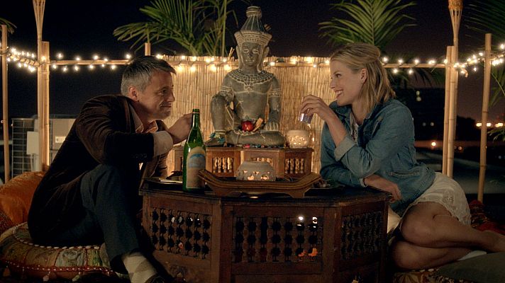 Cita romántica nocturna en azotea con decoración árabe, estatua de Buda y luces cálidas.  Vista previa de la película \"Loco de amor\".