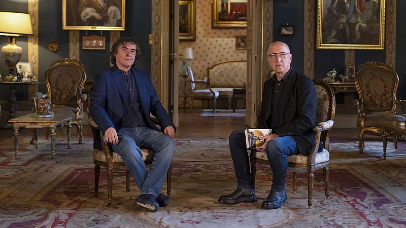 Vista previa de la publicación "Página Dos", número 289. Dos hombres sentados en sillas antiguas en una habitación elegante.