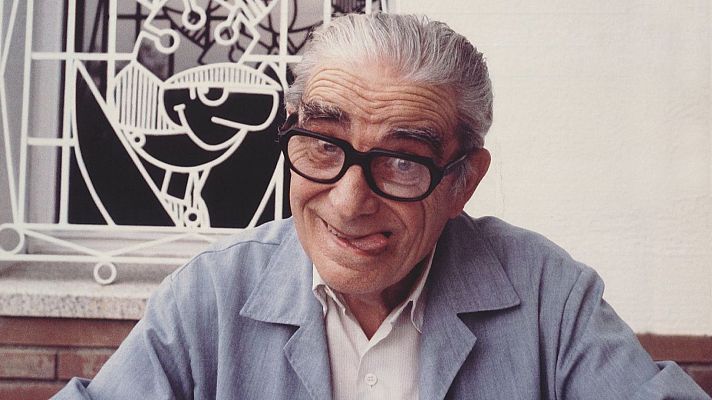 Fotografía de Josep Escobar, con gafas y expresión pícara, sobre fondo con pared y reja.  Texto superpuesto: \"Imprescindibles\".