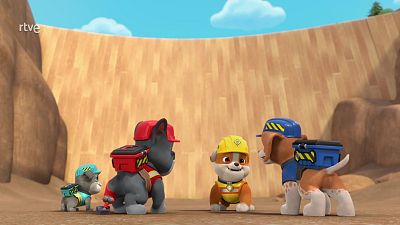 Cuatro cachorros de La Patrulla Canina (Rubble, Rocky, Chase y posiblemente Zuma) en una misión, con sus mochilas y cascos, en una zona que parece una excavación.