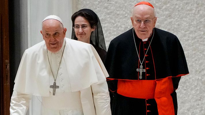 El Papa Francisco, un cardenal y una religiosa caminan juntos, vestidos con sus atuendos tradicionales.  Imagen de un evento formal.