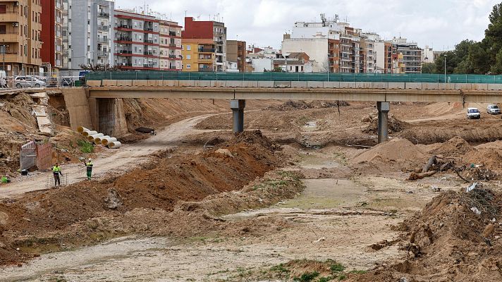 Dos operarios trabajando en el barranco del Poyo a su paso por la Paiporta
