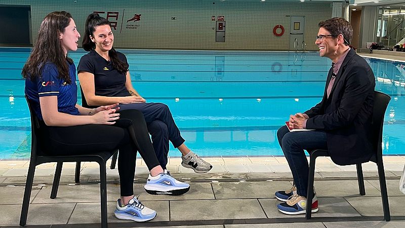 Entrevista junto a piscina: dos mujeres en ropa deportiva y un hombre con americana discuten, posiblemente sobre los Juegos Olímpicos.