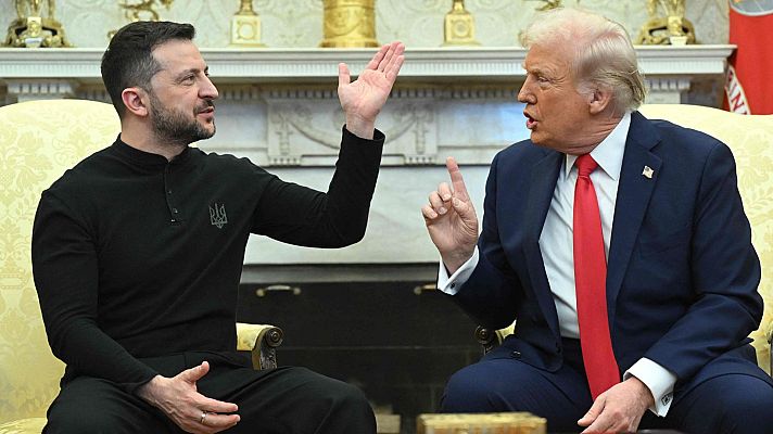 Zelenski y Trump, en una sala clásica, conversan; él con camiseta negra y gesto abierto, él con traje azul y señalando.