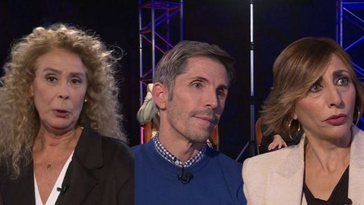 Entrevista en plató de televisión o radio con tres mujeres: una con chaqueta oscura y pelo rubio, otra con jersey azul y pelo canoso, y una tercera con chaqueta clara y pelo castaño. Todas llevan micrófonos.