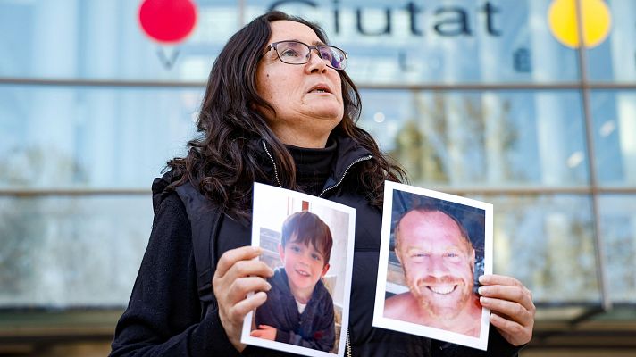 Ana María Coll muestra las fotos de dos de sus allegados a las puertas de la Ciudad de la Justicia de València