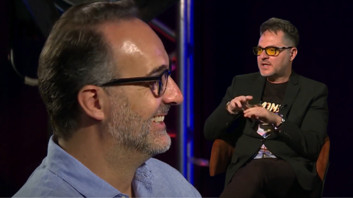 Entrevista a Javier Fesser, director de cine español, quien viste americana negra y gesticula; otro hombre, de camisa azul, escucha atentamente.