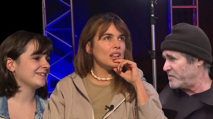 Entrevista en estudio de televisión con Najwa Nimri, una mujer con chaqueta vaquera y un hombre con gorro.  Ambiente de concentración, luces de colores y estructura metálica de fondo.