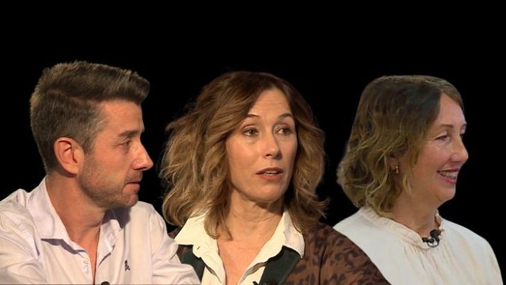 Entrevista o debate con tres personas: un hombre y dos mujeres con ropa formal, mirando fuera del encuadre.  Se ve el texto \"Voces maestras_Documentalista Haz\".