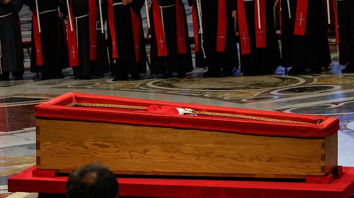 Ataúd simple de madera con forro rojo en una iglesia.  Funeral del Papa Francisco, enterrado según su deseo en Santa María la Mayor.