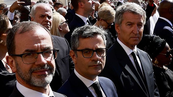Imagen de Félix Bolaños y Alberto Núñez Feijóo en un acto público con multitud de personas vestidas de oscuro.