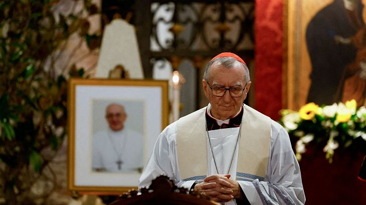 Imagen del Cardenal Parolin orando, con una foto del Papa Francisco al fondo.  Ambiente solemne, posiblemente un funeral.