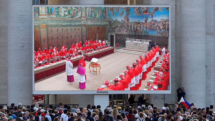 La gente mira una pantalla en la Plaza de San Pedro que muestra a los cardenales en la Capilla Sixtina, en el primer día del cónclave para elegir al próximo Papa