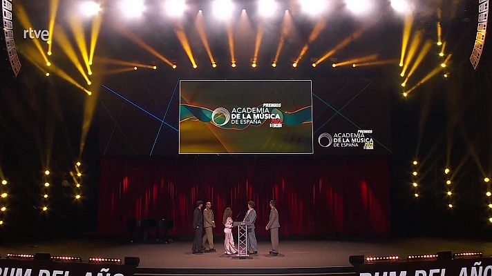 Gala de los Premios de la Academia de la Música de España.  Escenario con cuatro personas, logo del evento en pantalla central y logo RTVE en la esquina superior izquierda.