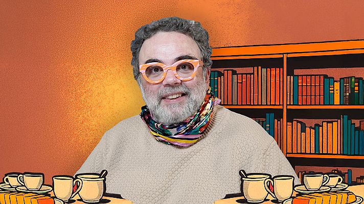 Bob Pop, con gafas naranjas y pañuelo, sentado a una mesa con café y dulces, frente a una estantería con libros.  Imagen promocional.