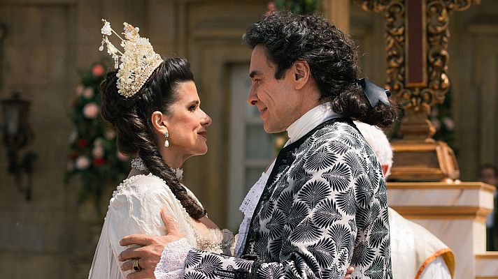 Boda en entorno palaciego: pareja abrazada, ella con vestido blanco y corona, él con traje de época.  Escena religiosa al aire libre. Avance episodio 230, temporada 2.
