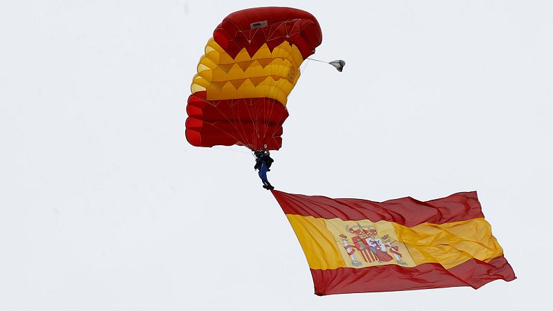 Salto con la bandera de España en el desfile del Día de la Fiesta Nacional