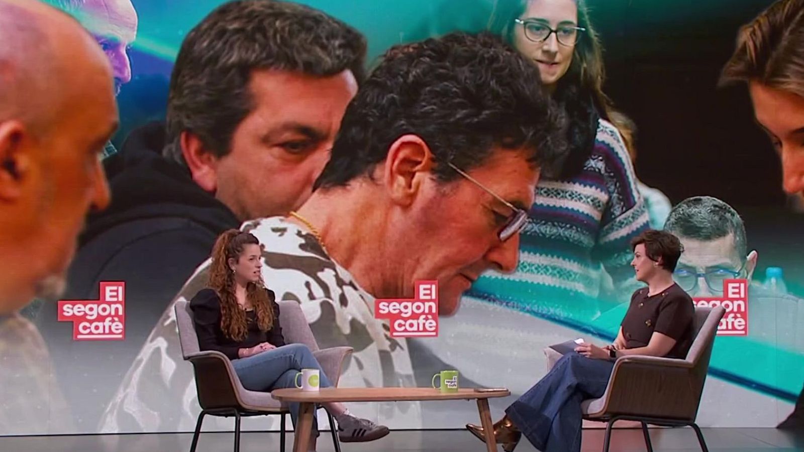 Dues dones seuen en un plató de televisió, enfrontades, amb una taula petita entre elles i tasses. Una d'elles, Ariadna Rebato, vesteix de negre i texans, i l'altra, Cristina Villanueva, porta una blusa fosca i pantalons acampanats. Al fons, una pantalla mostra imatges i el logotip d'un programa.