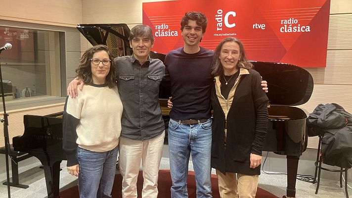 Cuatro personas posan en un estudio de radio, con un piano de cola y el logo de una emisora al fondo. Los individuos, dos mujeres y dos hombres, visten ropa casual y miran a la cámara.