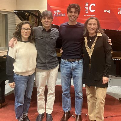 Cuatro personas posan en un estudio de radio, con un piano de cola y el logo de una emisora al fondo. Los individuos, dos mujeres y dos hombres, visten ropa casual y miran a la cámara.