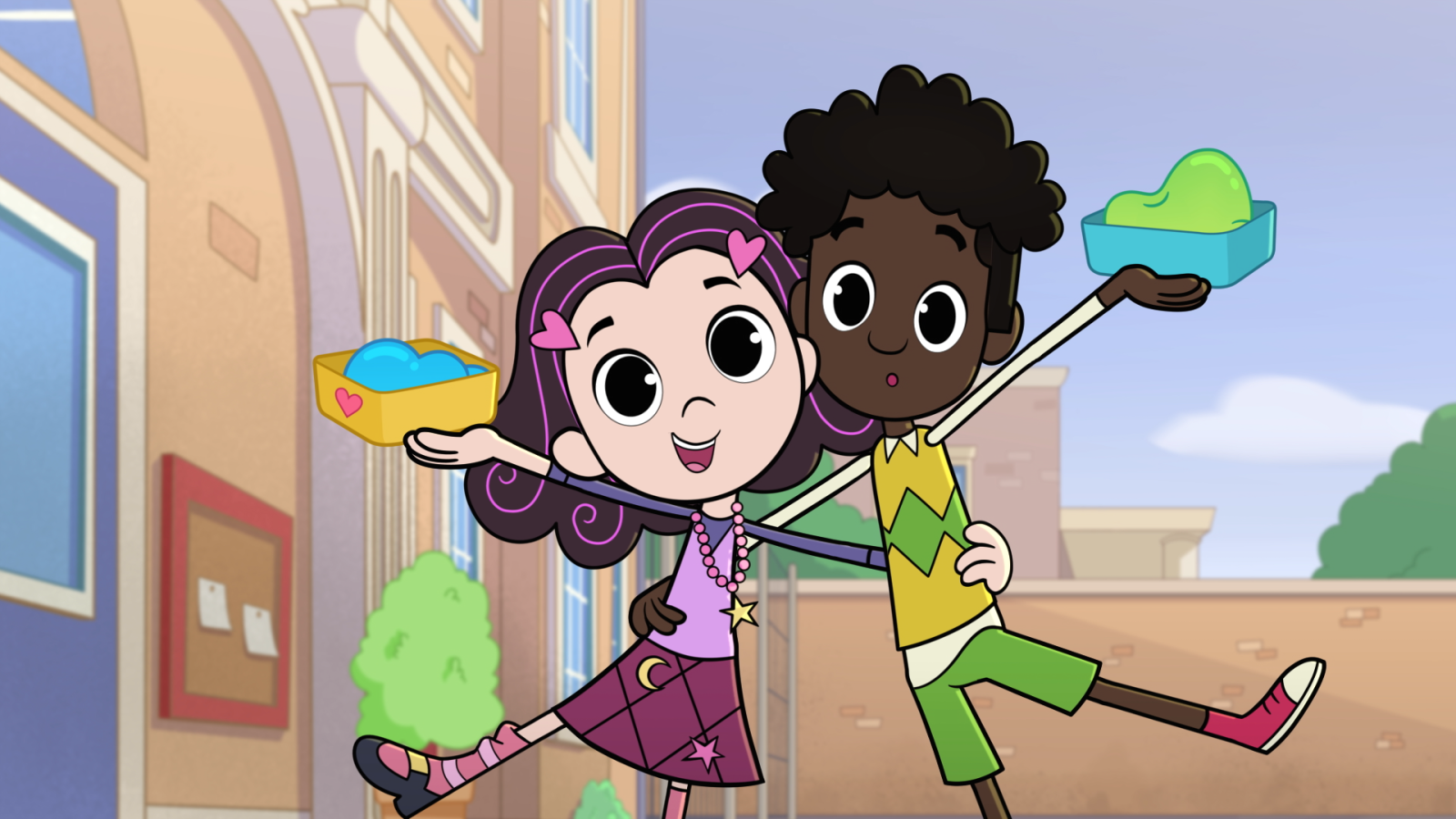 Dos niños, posiblemente Isadora Moon, juegan en un patio de recreo. La niña, con adornos de corazón y falda a cuadros, sostiene una caja amarilla con una sustancia azul. El otro niño, con camiseta amarilla, tiene una caja azul con una sustancia verde.