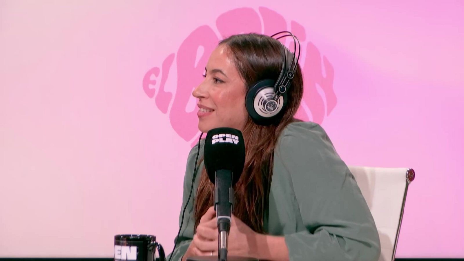 Marina Pérez, con auriculares y micrófono, participa en el episodio 11 de "El Brain". Viste una camisa verde claro y está sentada frente a un fondo rosa con el logo del programa.